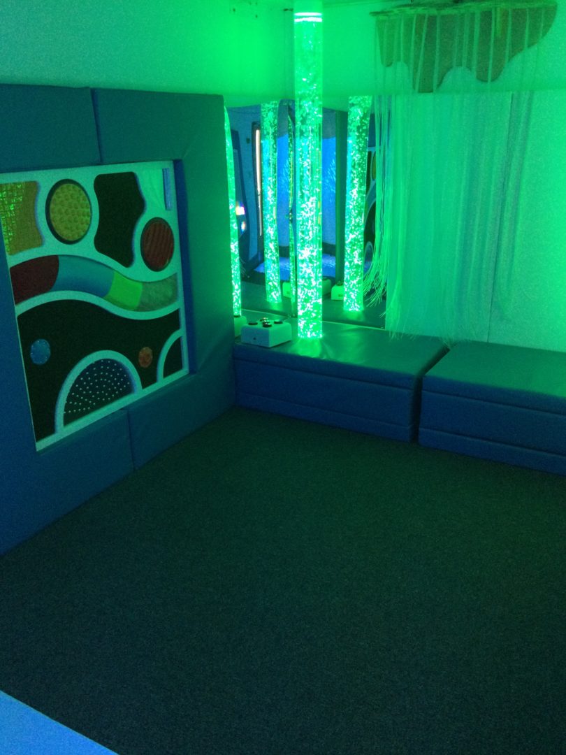 interactive bubble tube in soft padded plinth partnered with a passive controller and a tactile panel a snuzelen room